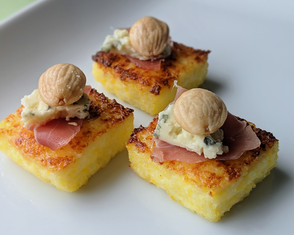 Crisp creamy polenta squares with prosciutto, blue cheese and marcona almonds