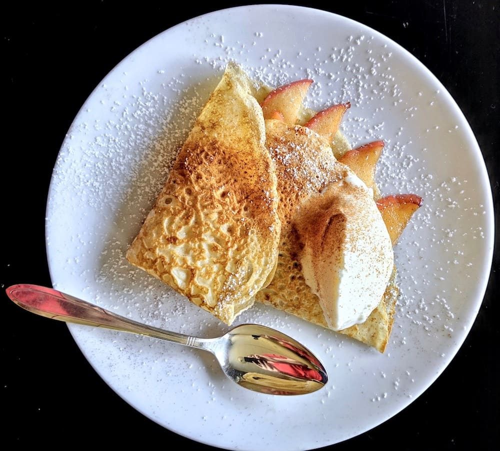 Soft crepe filled with cinnamon spiced apples and caramel and topped with vanilla ice cream