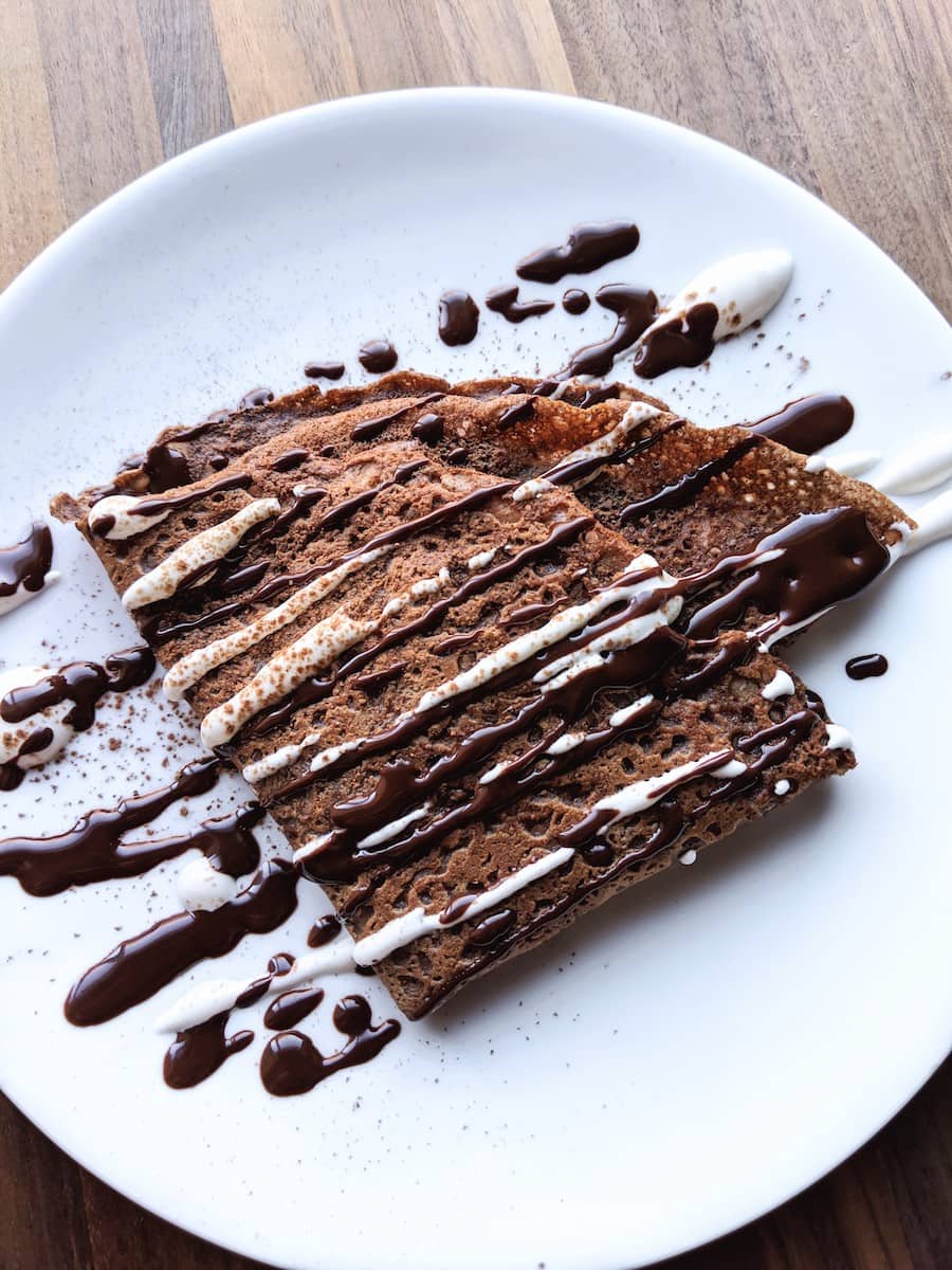 Tender chocolate crepe stuffed with dark chocolate mousse and topped with cream and ganache.