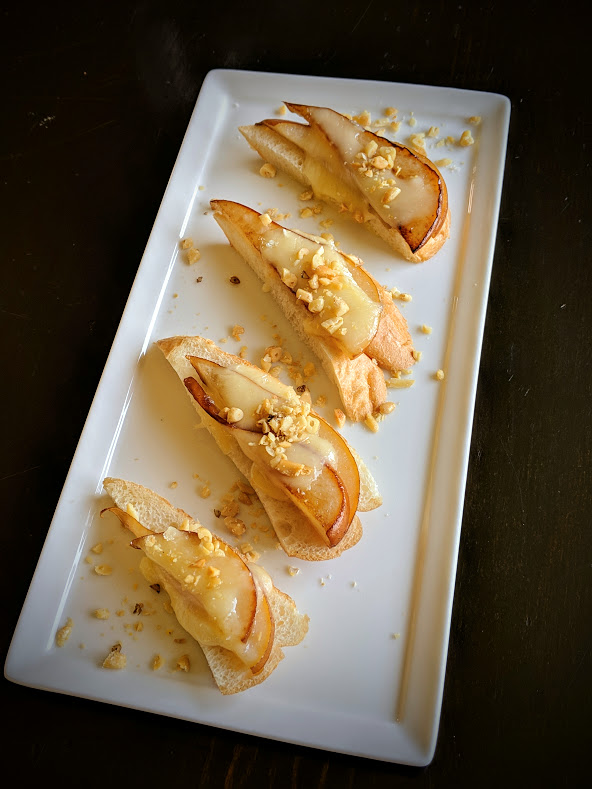 Crisp and light crostini topped with caramelized pear, brie and toasted pine nuts.