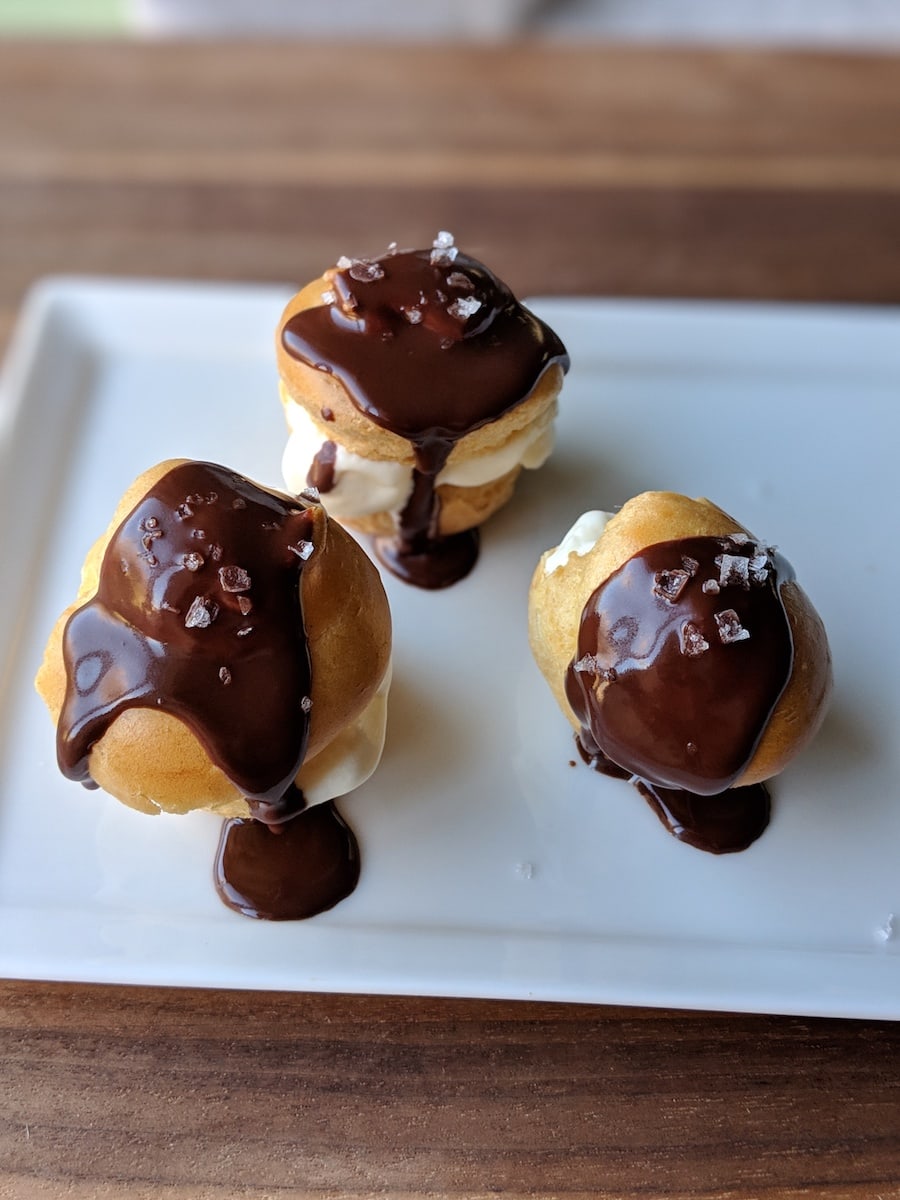 Cream puffs stuffed with vanilla bean ice cream and drizzled with warm chocolate sauce and Jacobson salt.