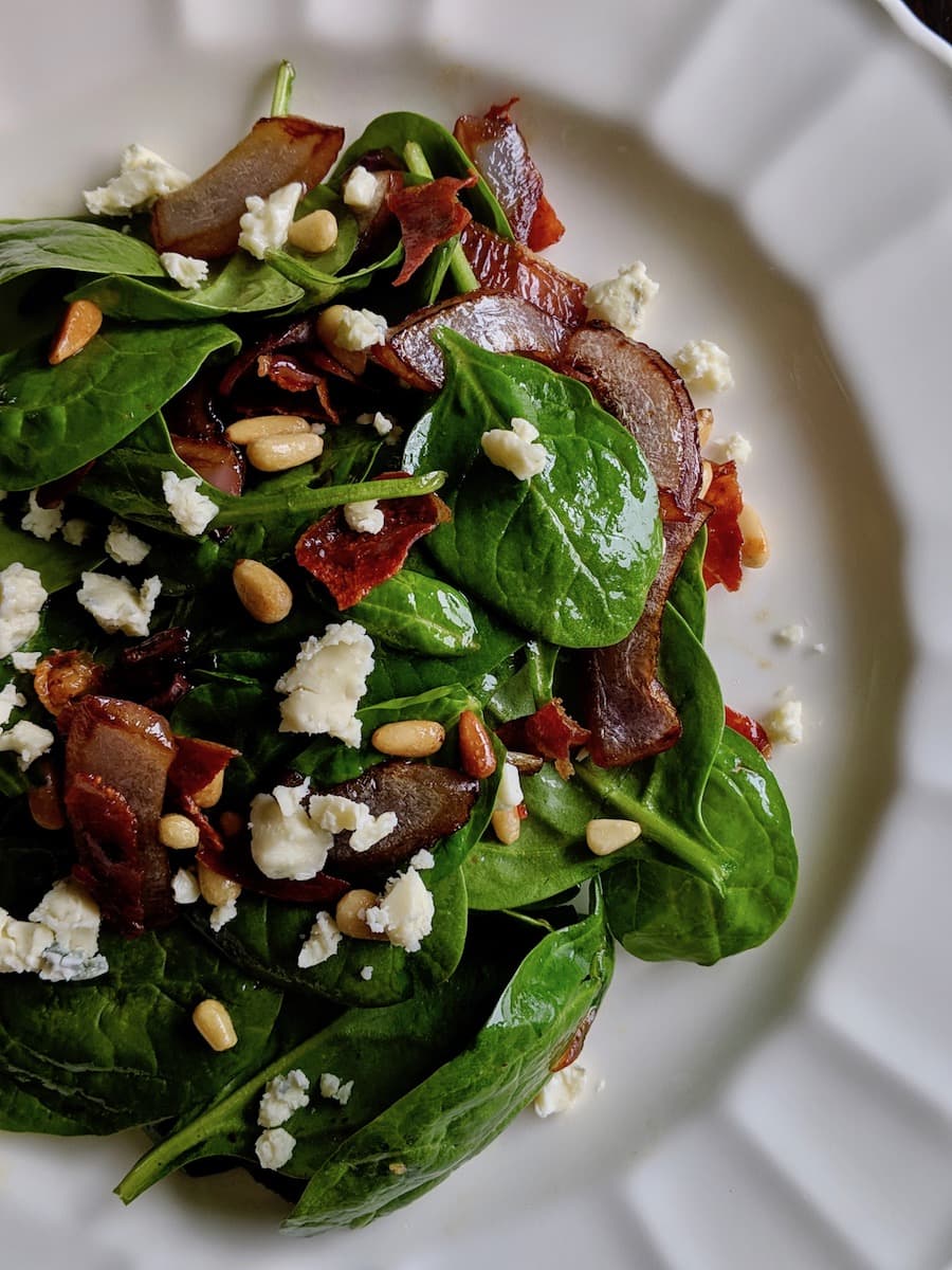 Warm Spinach Salad with Stilton, Crisp Prosciutto, Toasted Pine Nuts, Port Caramelized Onions and a Bacon Vinaigrette