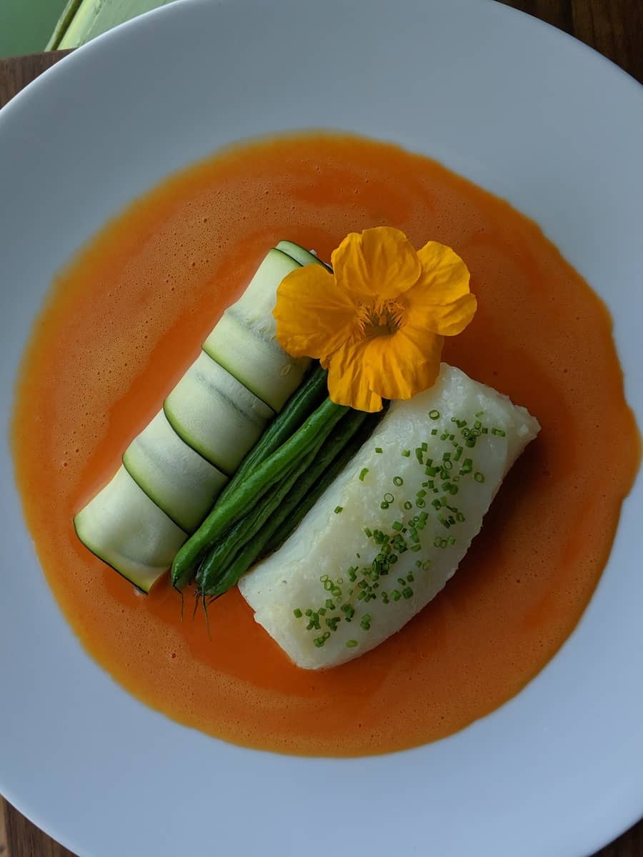 Cod with Bell Pepper Sabayon, Haricot Vert and Zucchini Cannelloni Stuffed with Mushrooms and Ricotta Cheese Elegant plate with cod filet, green beans and paper thin zucchini sheets wrapping ricotta cheese in a red pepper sabayon sauce
